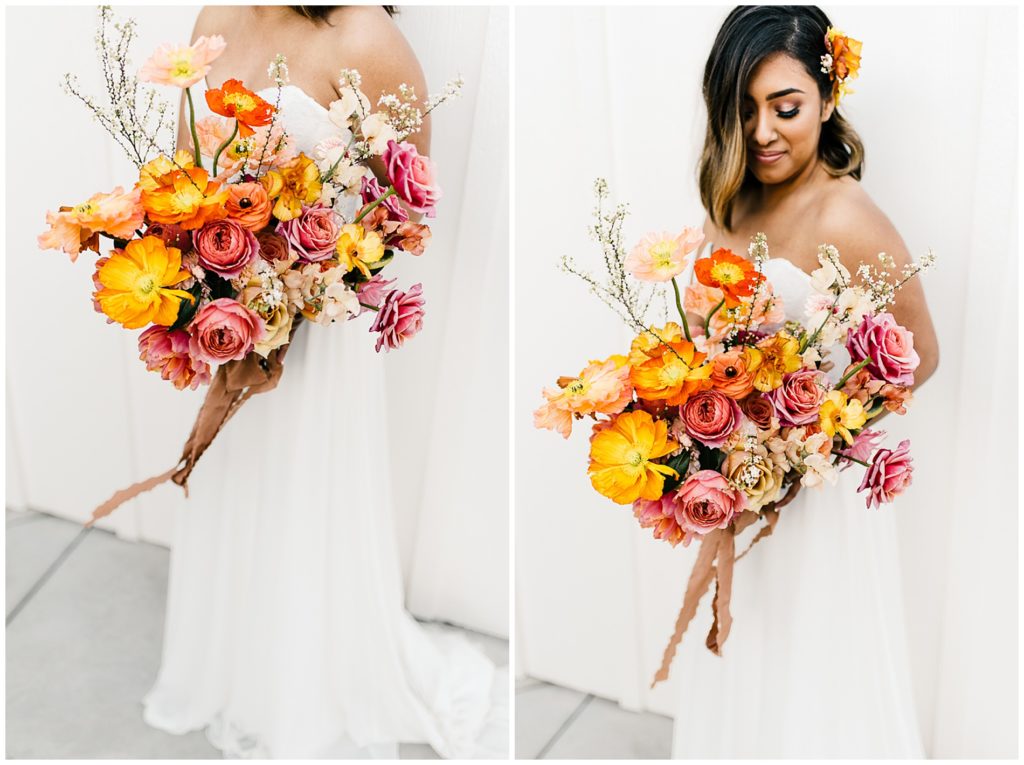 Bride holding a colorful spring bouquet with orange, yellow, pink, and coral blooms