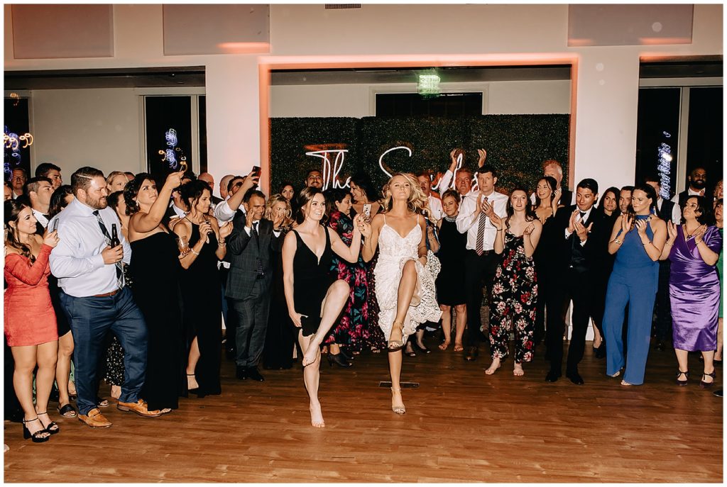 bride, groom, and guests dancing at wedding reception